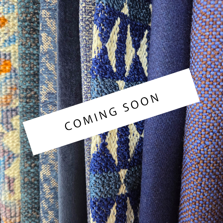 Mehrere verschiedenfarbige hängende Bezugsstoffe mit einem „Coming Soon“-Banner.