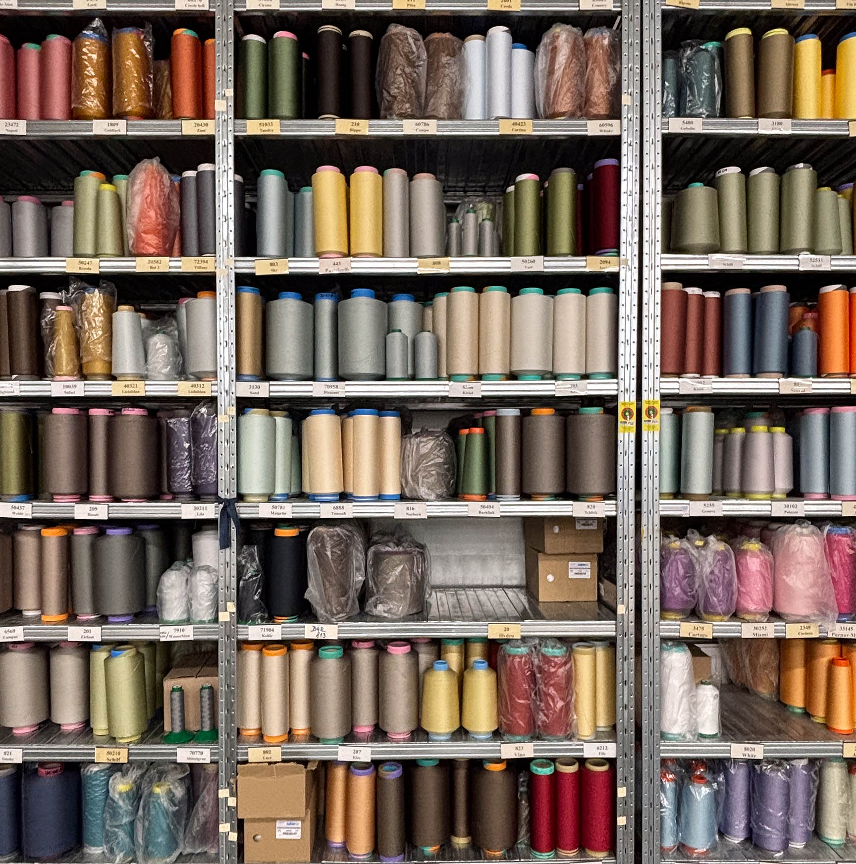 Yarn wall with rolled yarn stored on shelves