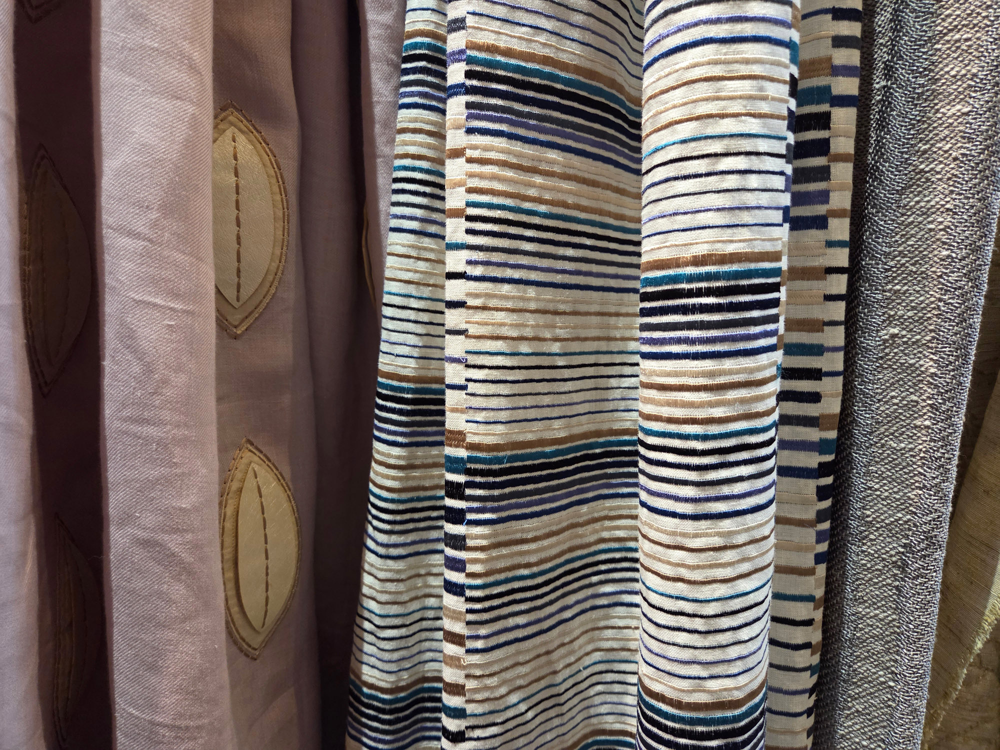 Verschiedenfarbige Designer-Deadstock-Bezugsstoffe in unterschiedlichen Texturen und Mustern.