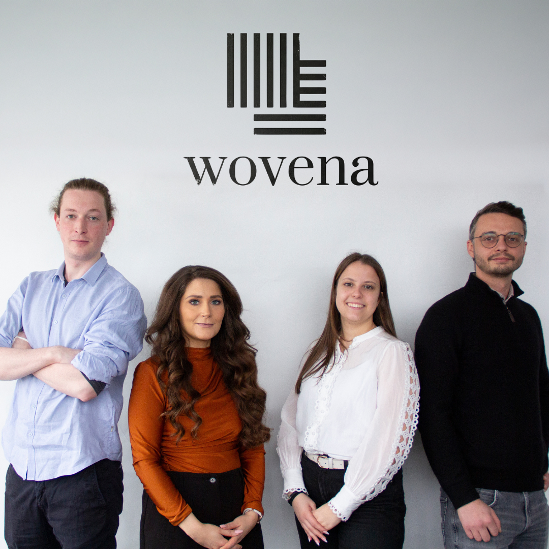 Teammitglieder von Wovena stehen gemeinsam am Unternehmenssitz.